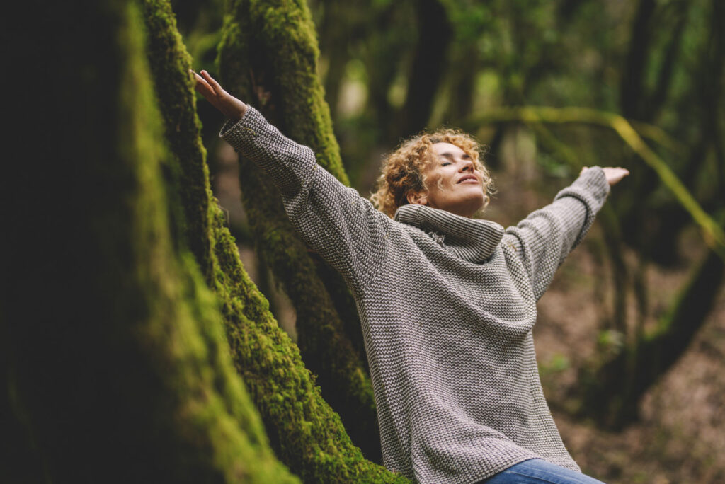 Overjoyed happy woman enjoying the green beautiful nature woods