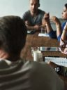 Managers en discussion autour d'une table en bois lors d'un atelier managérial