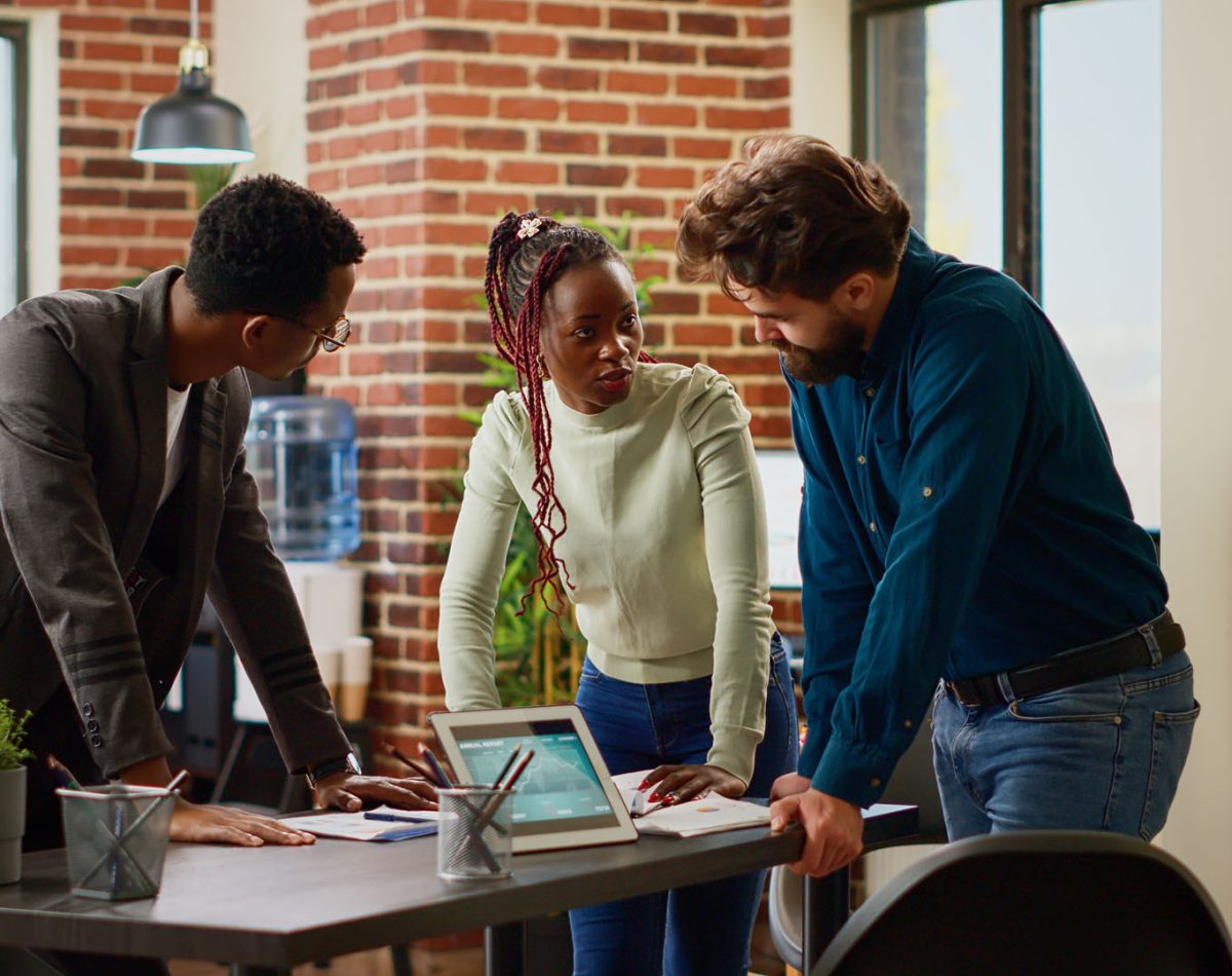 Multiethnic group of coworkers analyzing information on charts